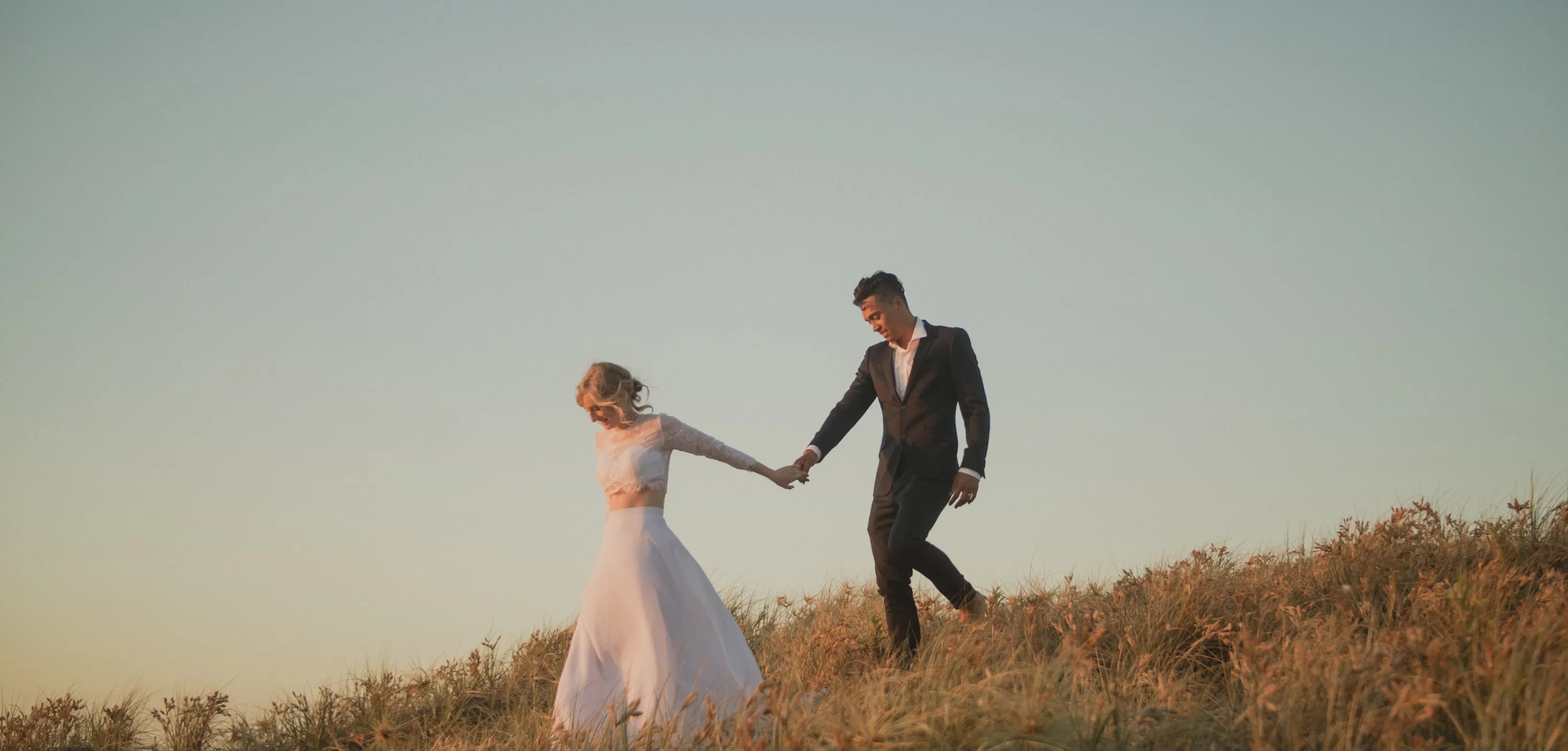 Wedding videography New Plymouth - David and Naomi walking along the Whanganui coastline