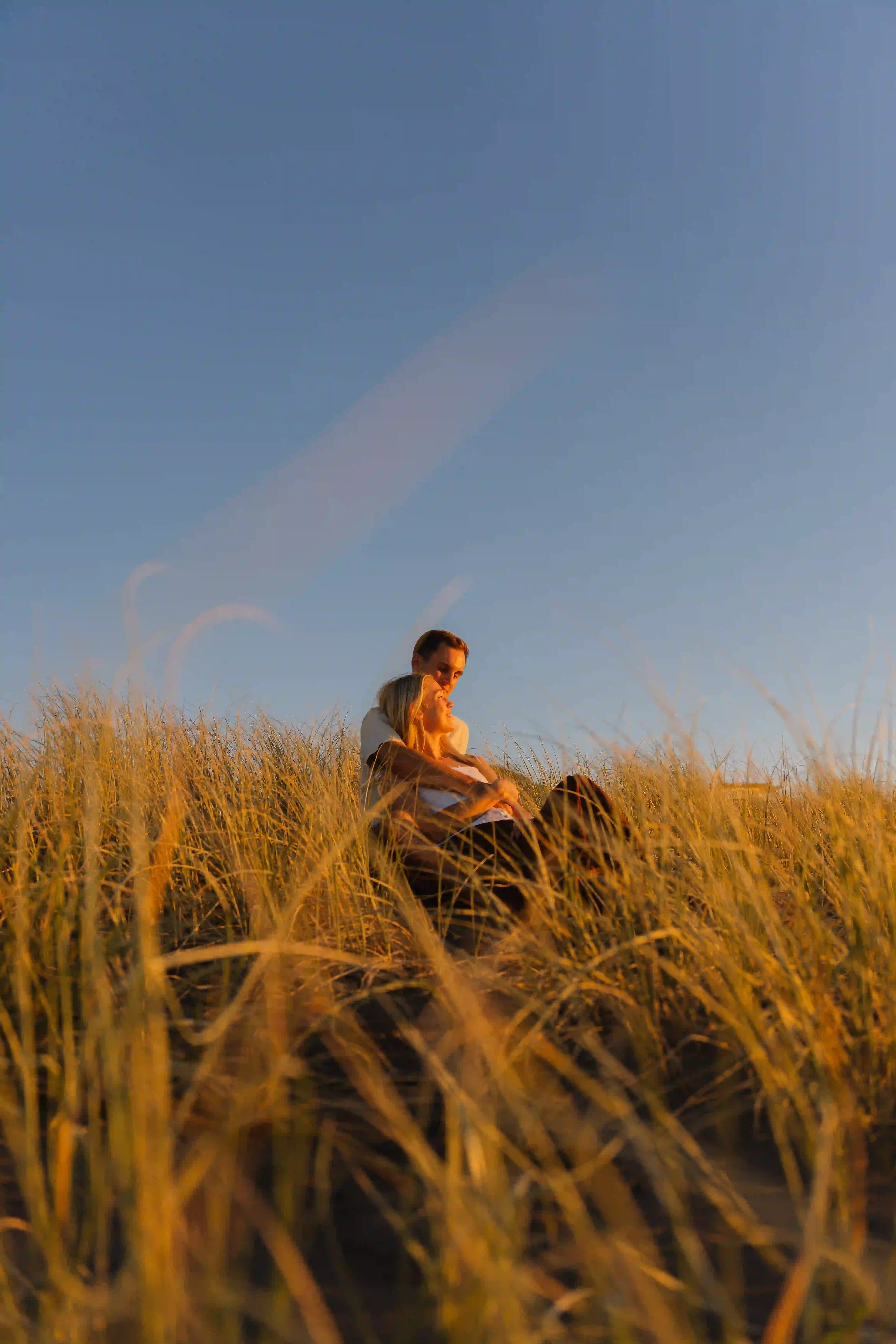 Couple standing together on windswept dunes